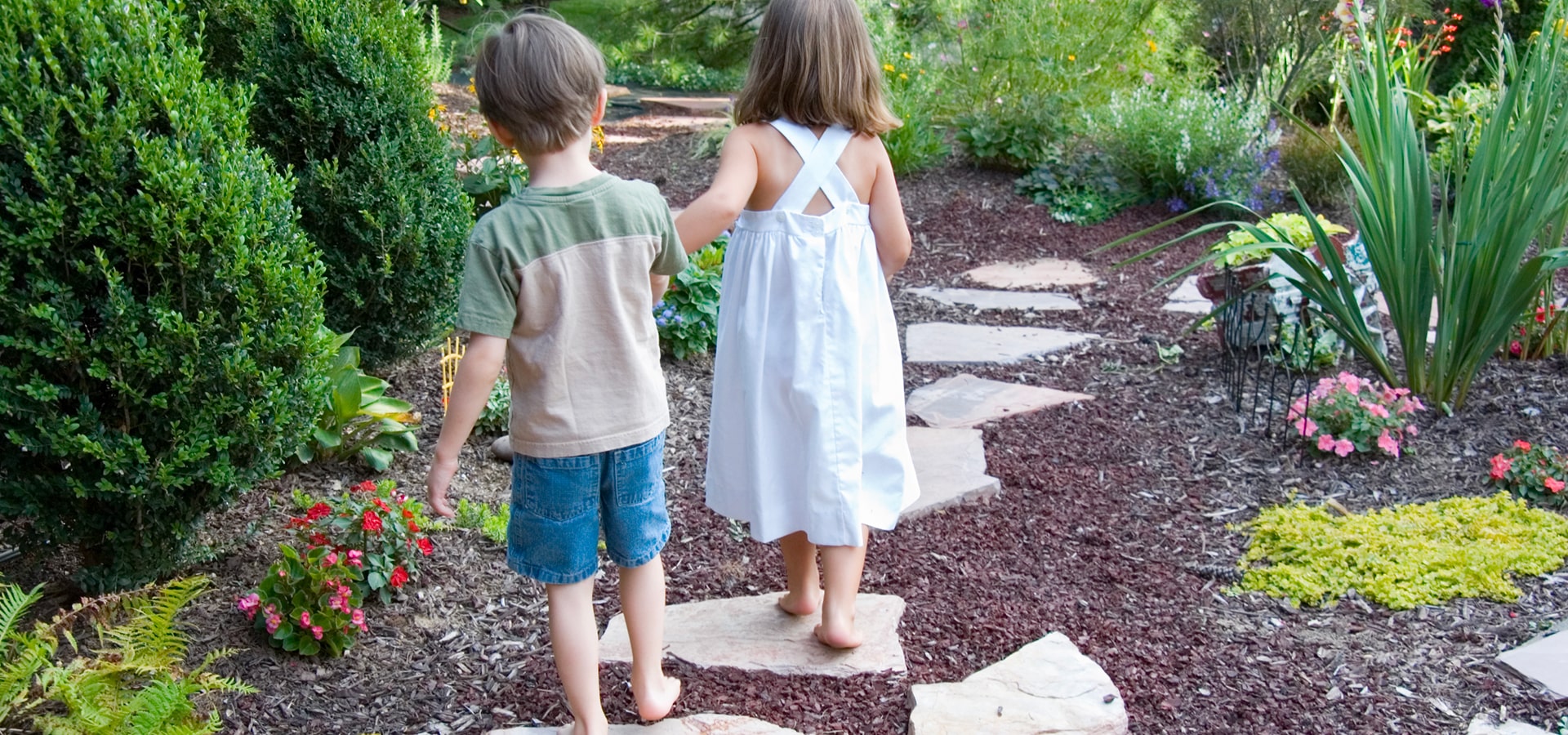 Due bambini che passeggiano nel giardino
