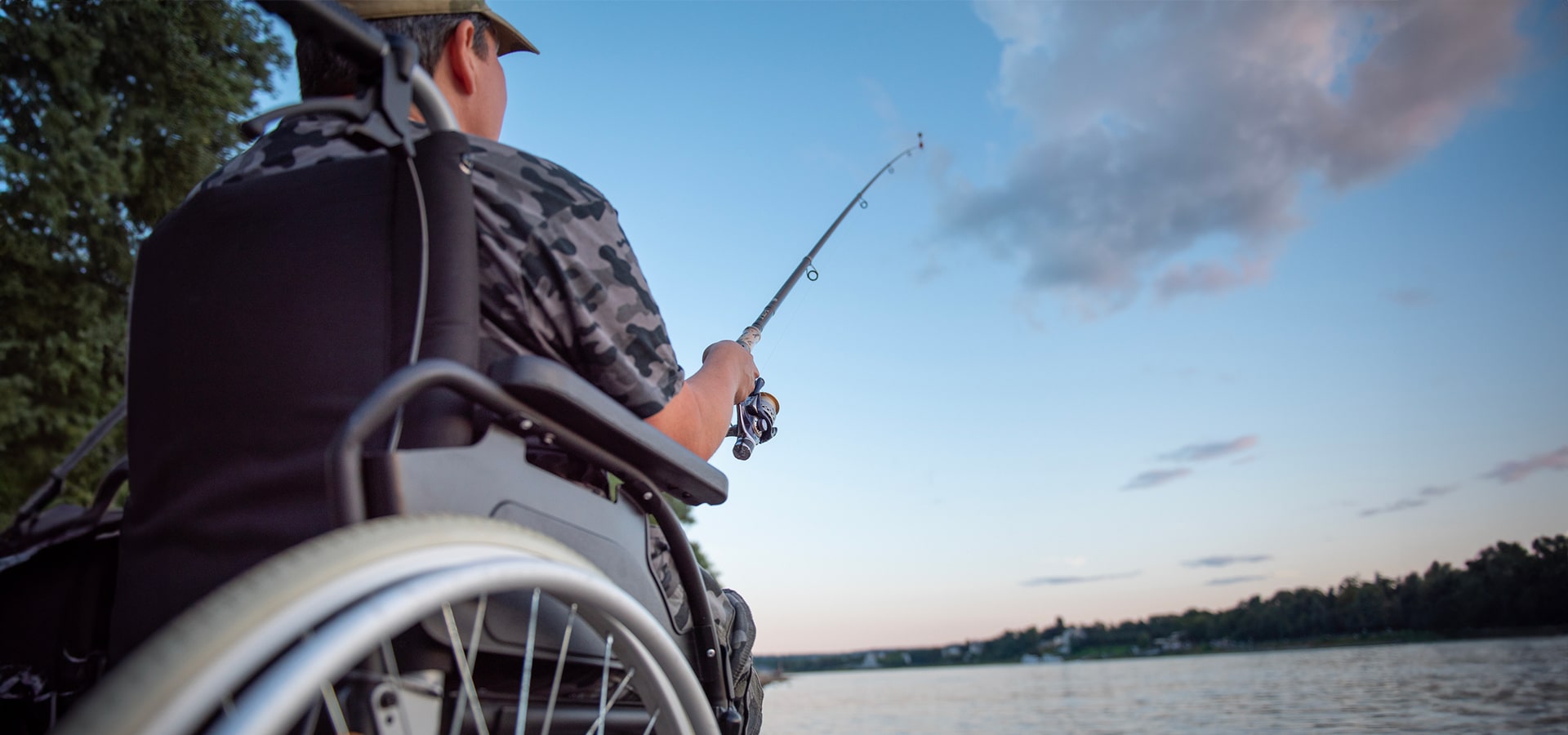 Ragazzo in sedie a rotelle che fa pesca